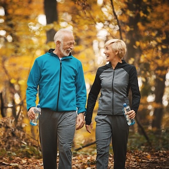 Give support, get support. An image of a couple hiking in the fall leaves.