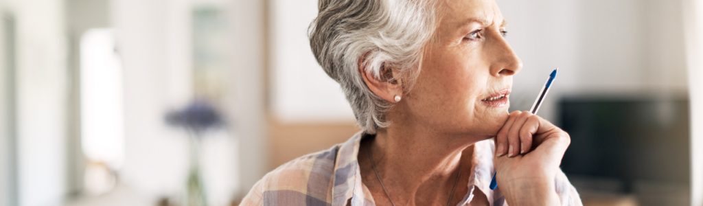 Shot of a senior woman looking thoughtful while holding a pen at home